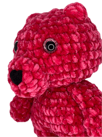 a red crocheted teddy bear is shown against a black background