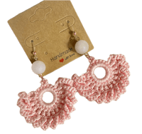 a pair of crocheted pink earrings with white beads