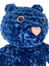 a blue teddy bear with pink eyes