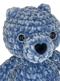 a blue teddy bear on a black background