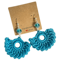 a pair of crocheted earrings with blue beads