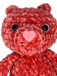 a red teddy bear with pink eyes