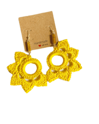 a pair of yellow crochet earrings on a card